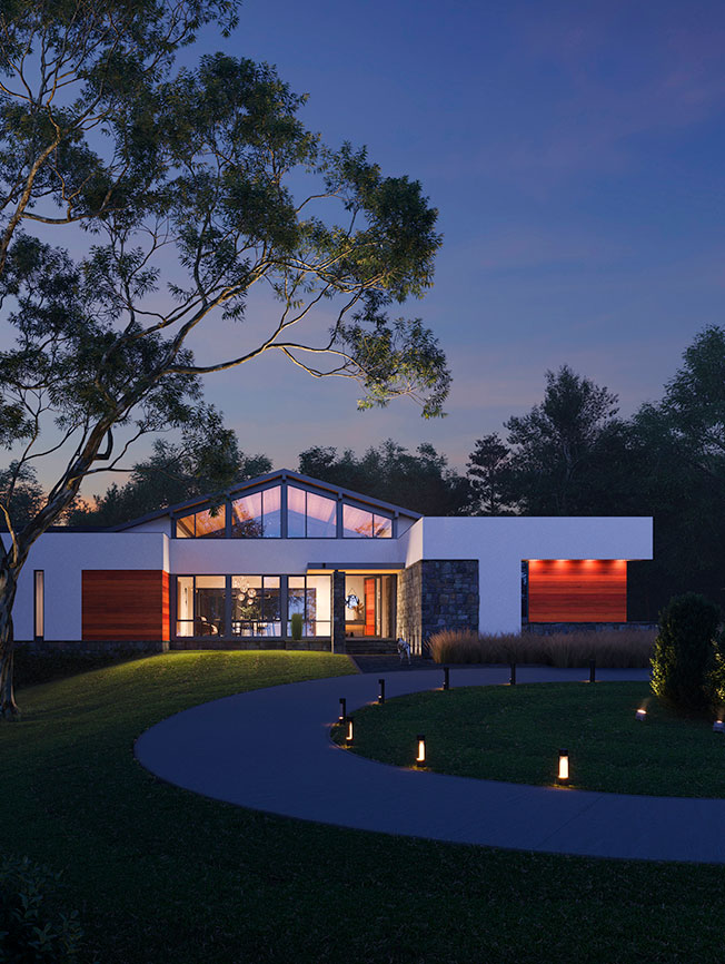 A California Modern style front exterior illuminated against wooded scenery and night sky.