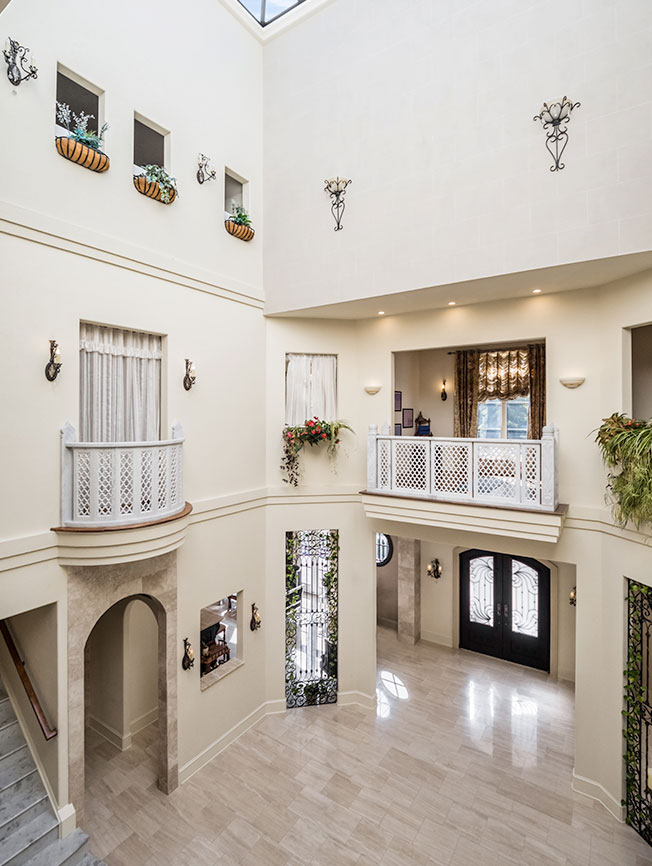A photo showing a two-story Atrium wall with Romeo and Juliet balcony, 2nd floor overlook and arched hallway below.