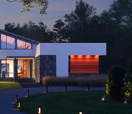 A California Modern style front exterior illuminated against wooded scenery and night sky.