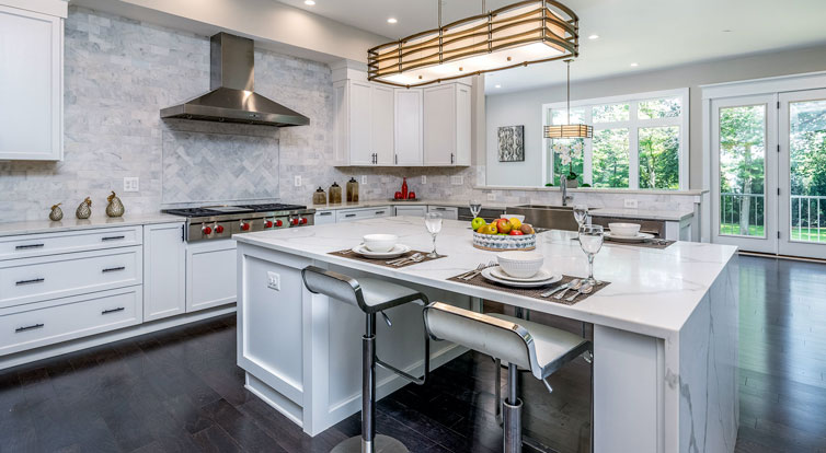 A custom kitchen with quartz waterfall island and counters, marble backsplash, and adjacent Morning Room.
