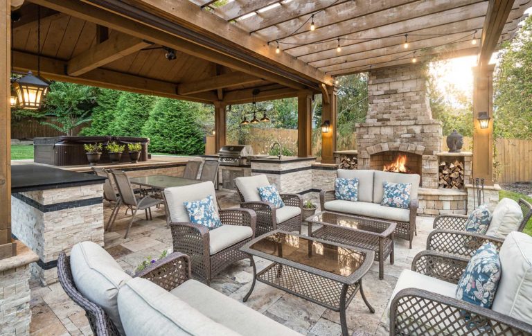 An elaborate patio with stone fireplace, flooring and walls, granite counters, wet bar, grill and raised hot tub.