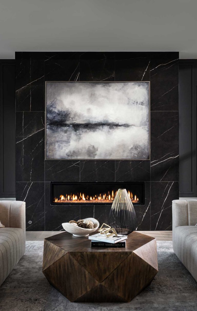 An oversized linear fireplace surround of dark Daltile Marble Attaché tile with dark windows and walls.