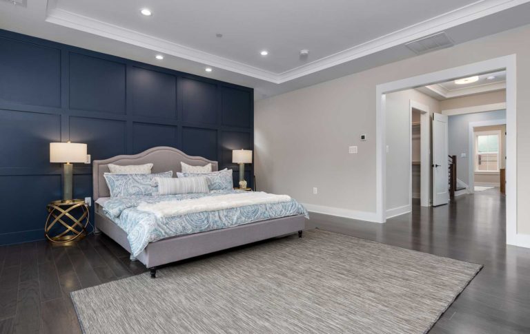 The owners suite bedroom with blue coffered accent wall and deep tray ceiling.