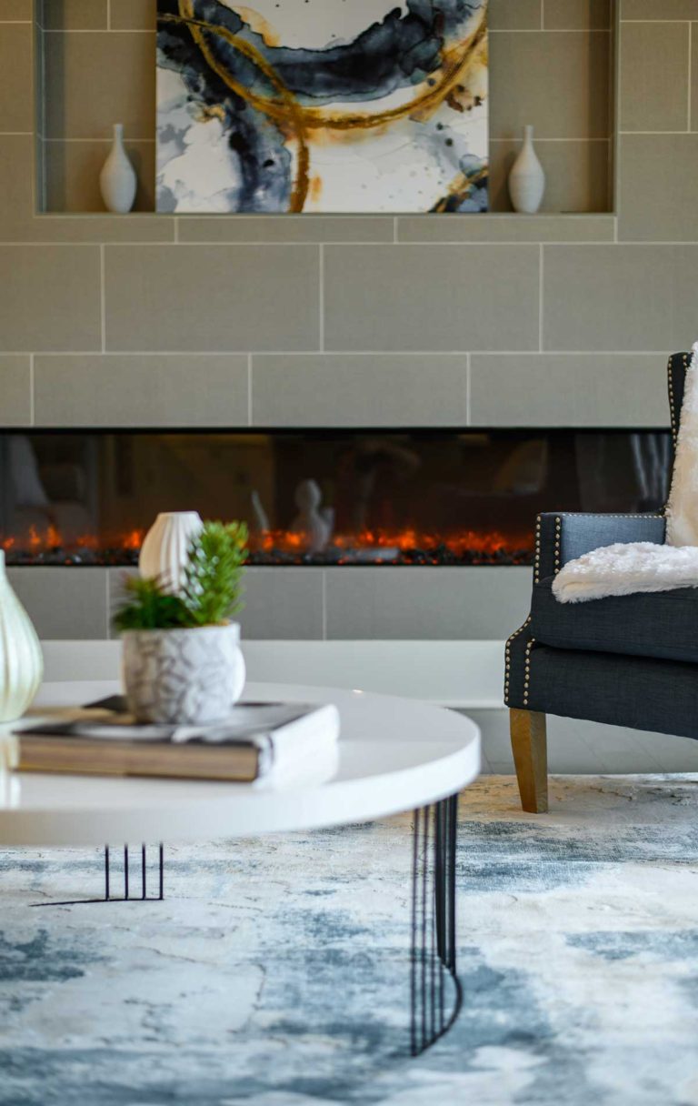 A detail photo showing a family room tile accent wall with linear fireplace and television niche