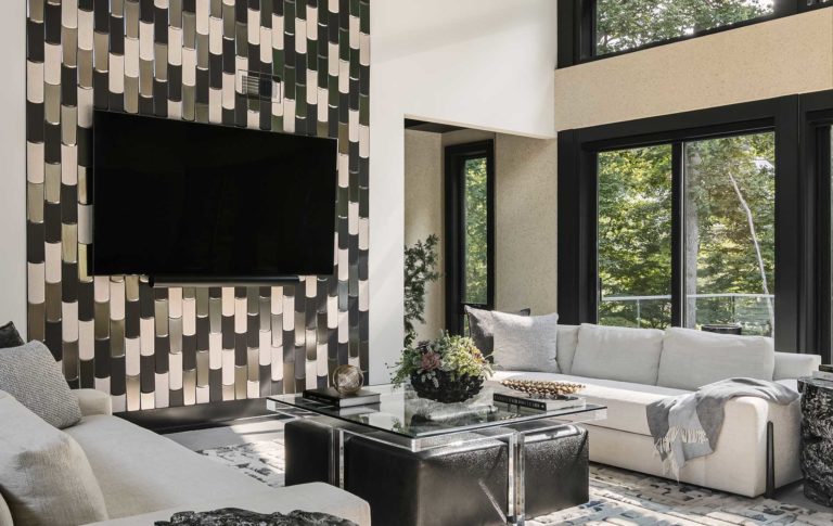 A floor-to-ceiling tile accent wall compliments the tall windows behind this Family Room.