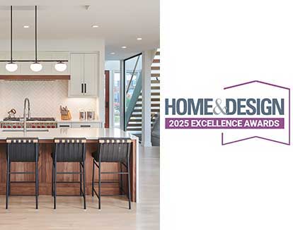 A modern kitchen and glass enclosed staircase with the Home & Design Excellence Awards logo