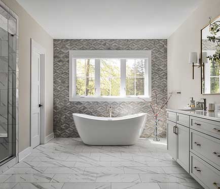 A free standing tub against tiled accent wall, shower and vanity to either side in the foreground