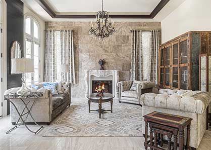 A luxury family room with tile wall, custom mold fireplace mantel, tile accent wall,tall windows and curtains.