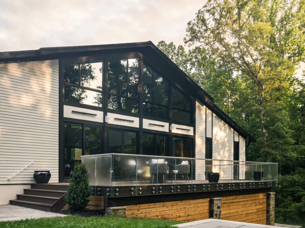 A wide photo shows the rear of the main level, looking into the deck and surrounding forest.