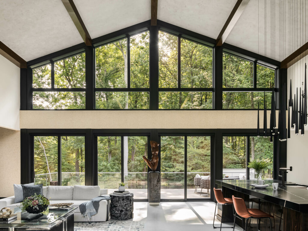 A wide photo shows the rear of the main level, looking into the deck and surrounding forest.