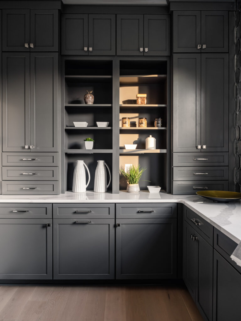 A unique Butler's Pantry of dark grey cabinets and shelving, white q quartz countertops.