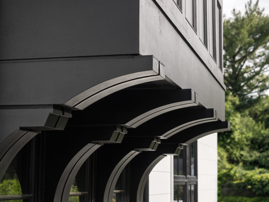 A close up photo of a row of four matching double brackets beneath a bay window