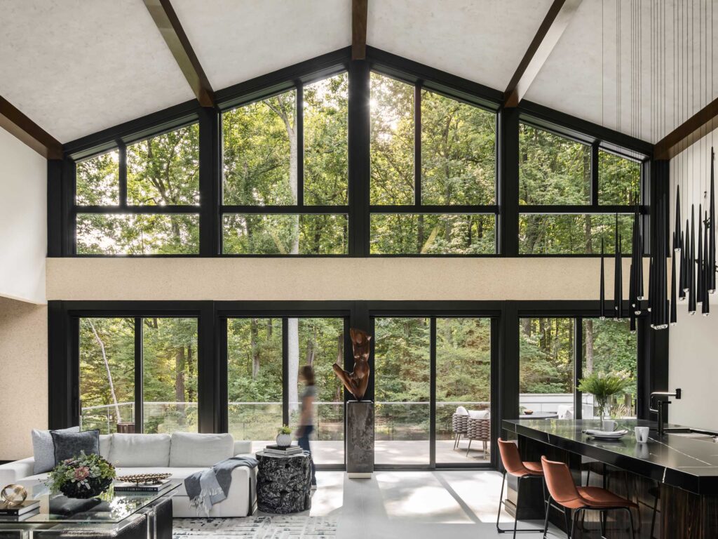 A wide photo shows the rear of the main level, looking into the deck and surrounding forest.