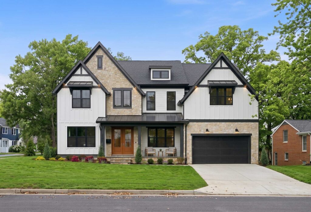 A modern two-story home with white board-and-batten siding, light stone accents, and black-trimmed windows.